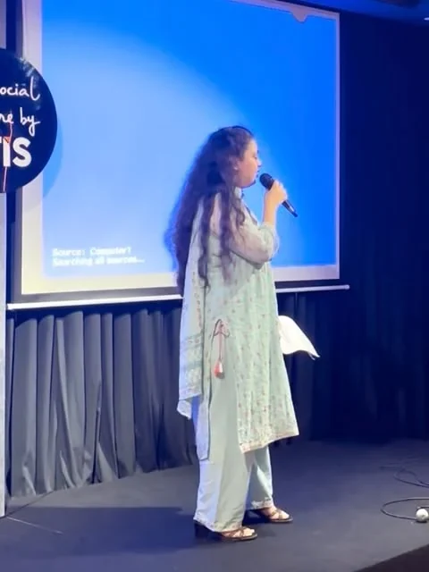 A speaker sharing ideas with an audience on stage