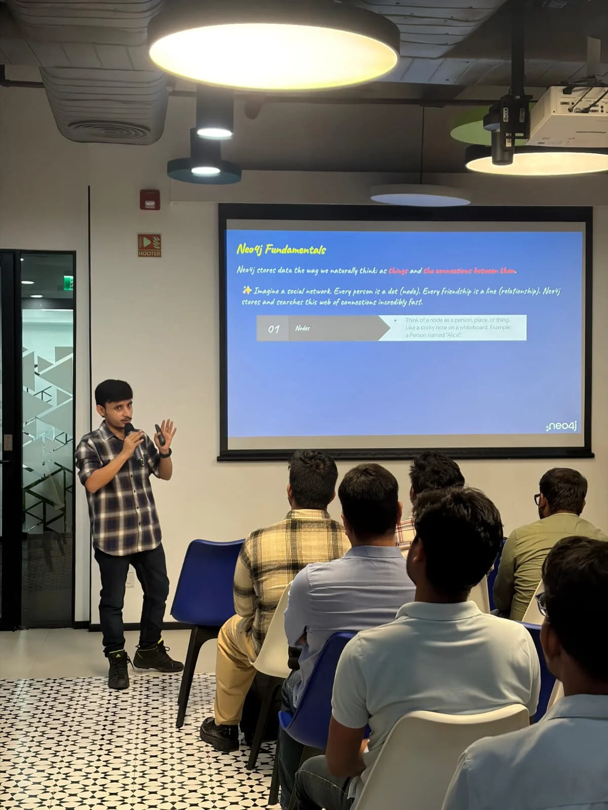 A speaker presenting Neo4j fundamentals to event attendees